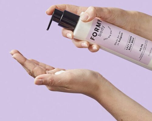 Une main tient le flacon de mon lait corps et en met dans une autre main