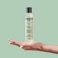 Une main tient mon gel douche Woody Wood 250ml