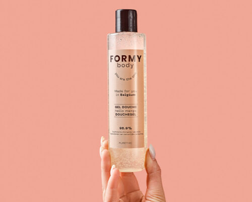 Une main tient mon gel douche Hello Mango 250ml