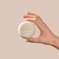 Une main tient mon shampoing solide tous types de cheveux et lavage fréquent