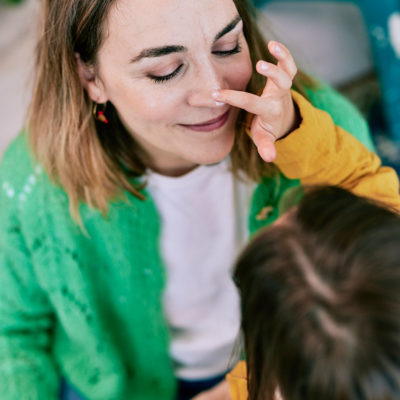 Enfant appliquant de la crème sur le nez d'une adulte