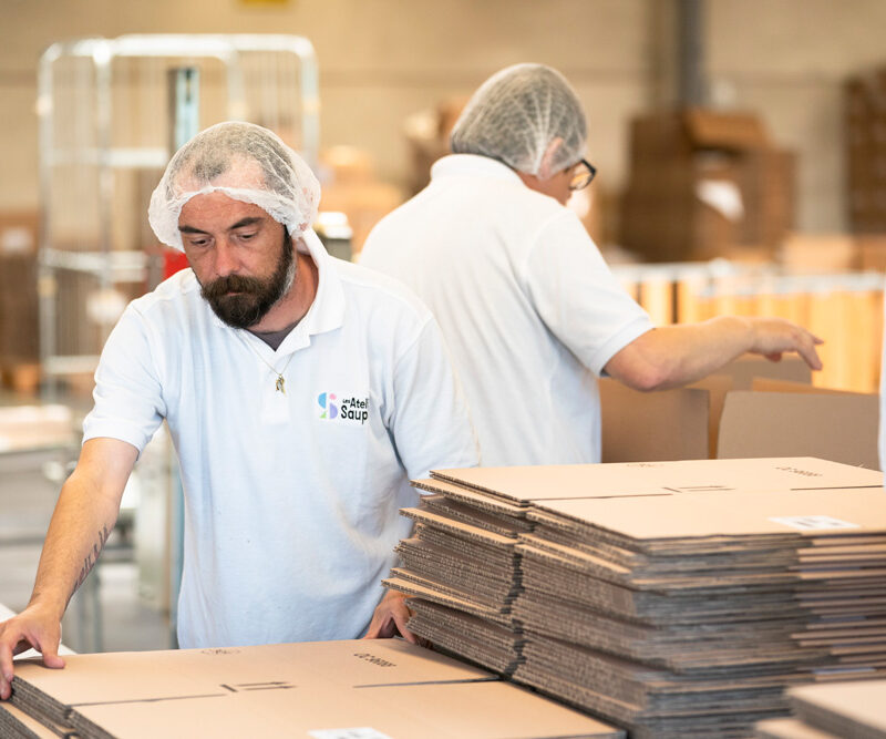 Hommes avec des charlotte sur leur tête pliant des cartons dans au Saupont