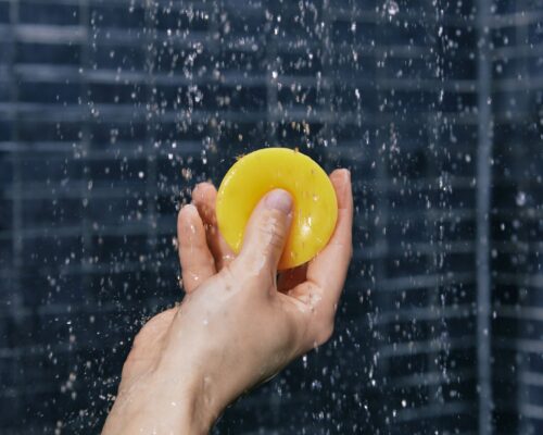 Main tenant un après-shampoing solide sous la douche