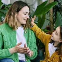 Une mère et sa fille. La petite fille met de la crème visage FORMY sur le visage de sa mère.