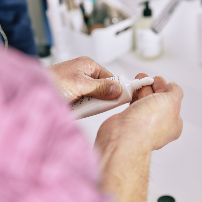 Mains d'homme qui s'applique de la crème sur la paume des dos