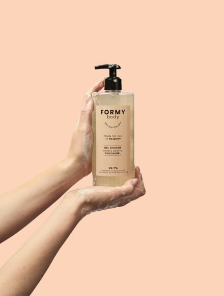 Deux mains tiennent le gel douche Sweety Peachy en 500ml, on peut voir la mousse onctueuse du produit sur les mains.