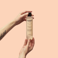 Une main tient mon gel douche Sweet Peachy 250ml