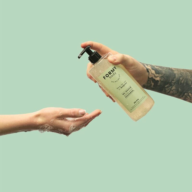 Une main verse mon gel douche Woody Wood 500ml dans une autre main