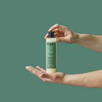 Deux mains tiennent mon shampoing homme