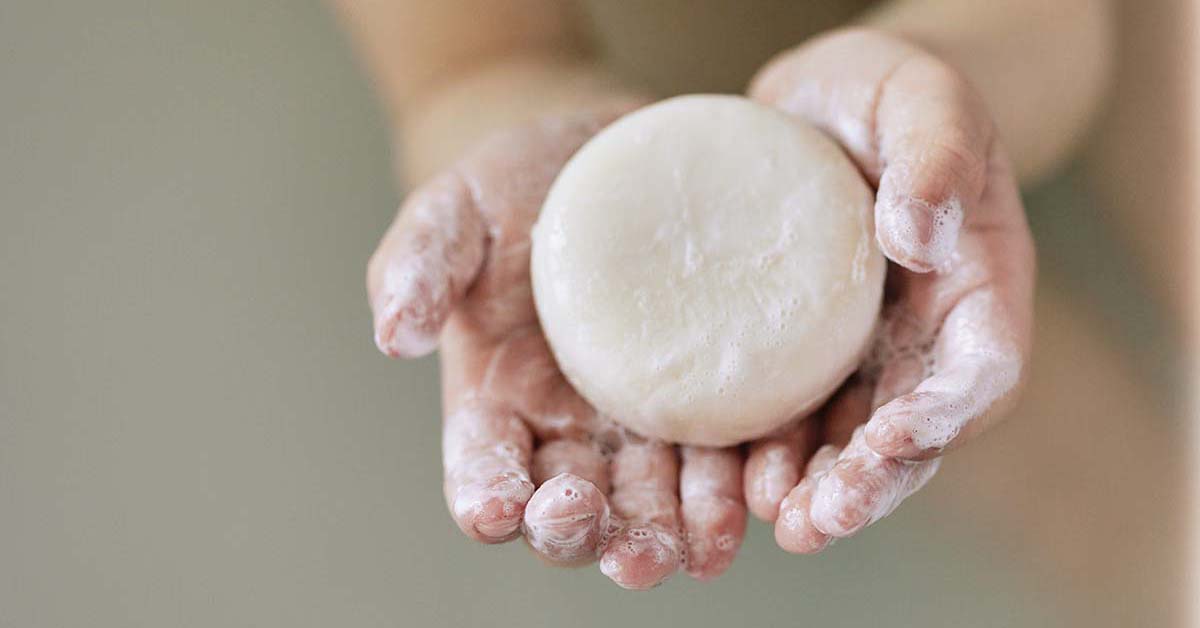 Photo d'un shampoing solide dans les mains d'un enfant