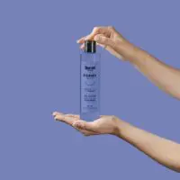 Deux mains tiennent un flacon de gel douche Berry'Licious