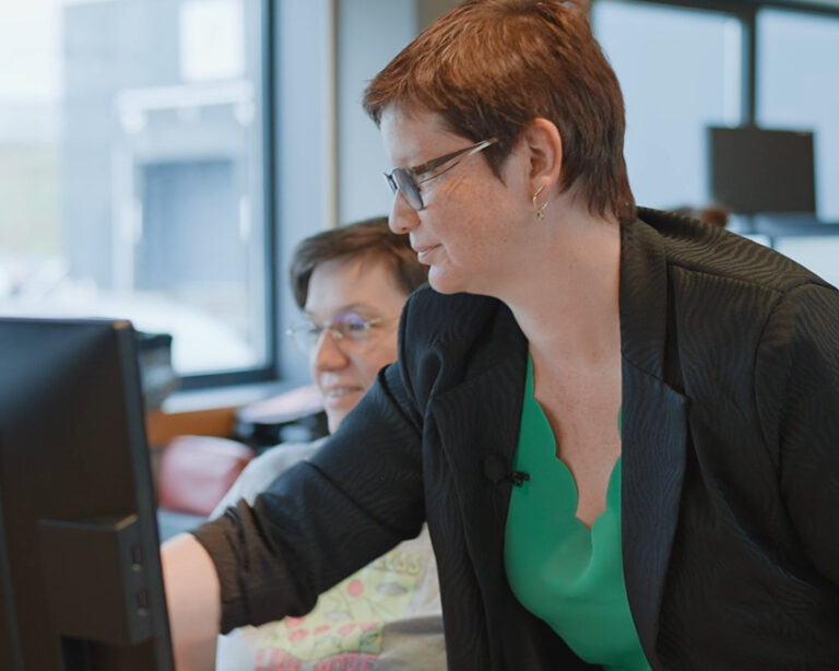 Photo de deux femmes devant un ordinateur dans leur bureau