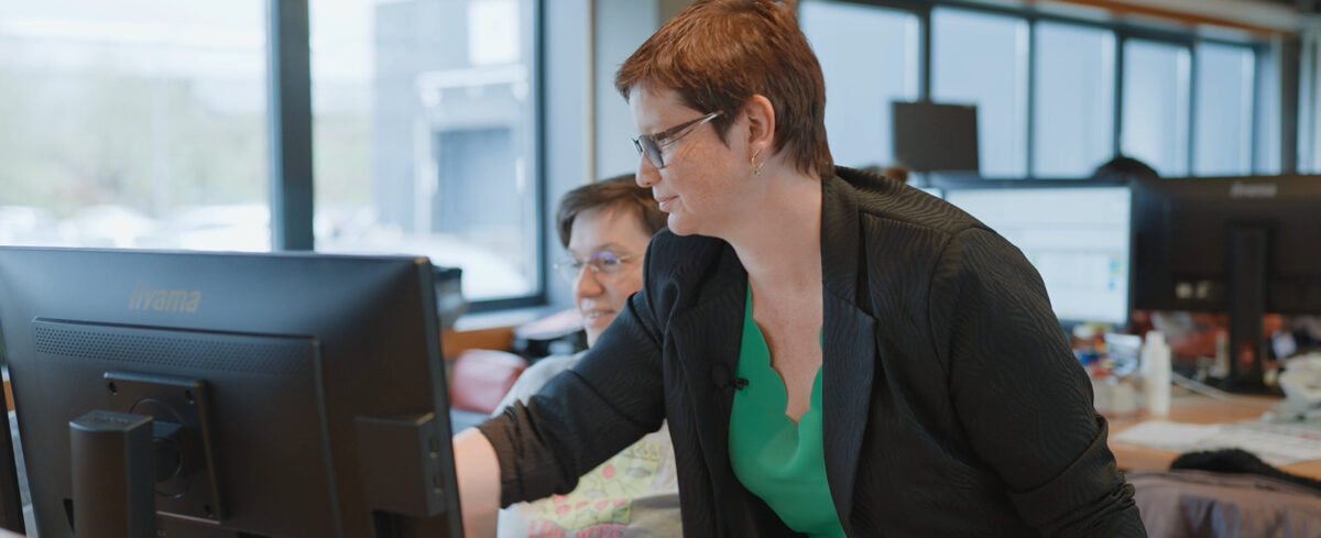 Photo de deux femmes devant un ordinateur dans leur bureau