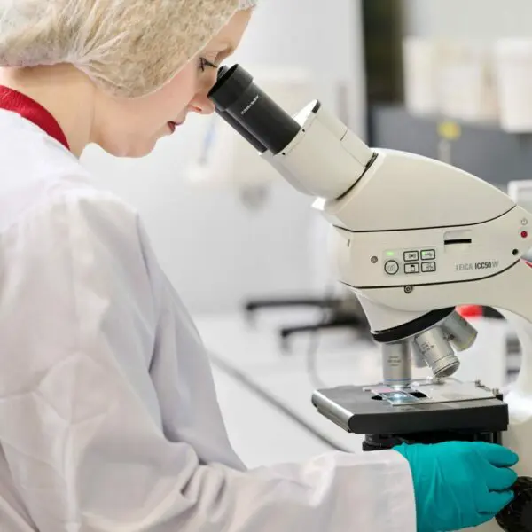 Ma cosmétologue en train d'utiliser son microscope 