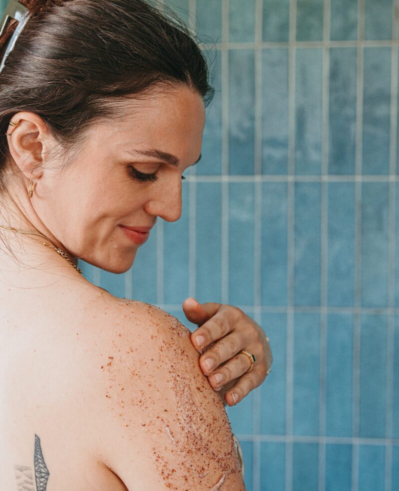 Une femme s'applique mon gommage corps sur le bras