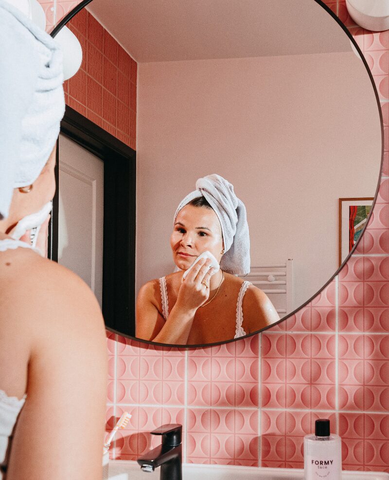 eau micellaire Une femme qui se démaquille à l'aide de mon eau micellaire et de mon coton démaquillant réutilisable
