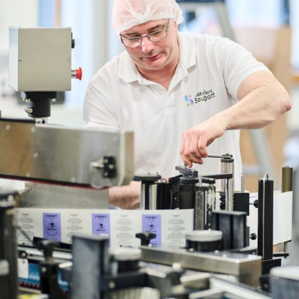 Un employé de l'usine qui assemble mon gel douche Berry'licious